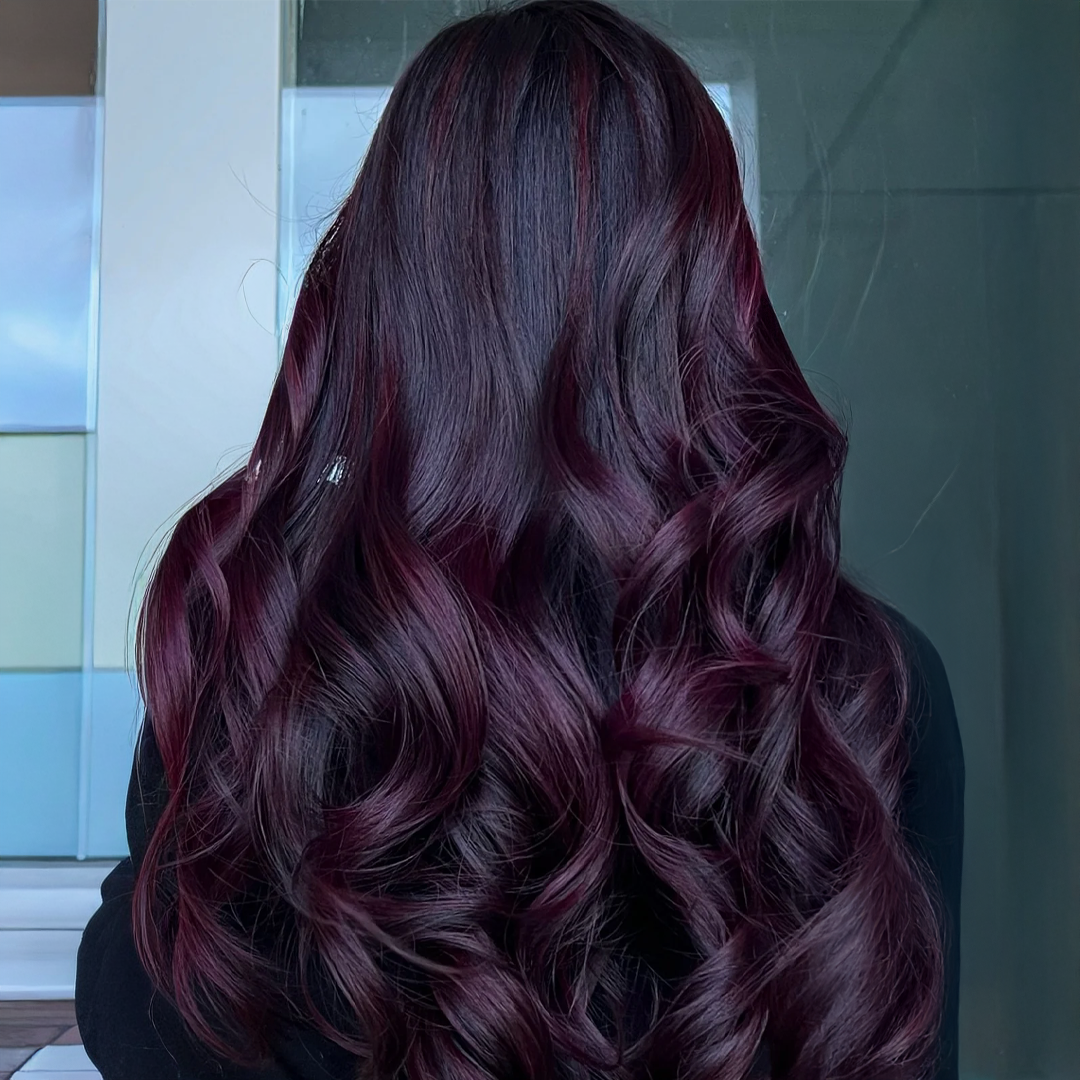 Model with sleek hair dyed in deep burgundy, showcasing one of fall 2025’s trending hair colours.